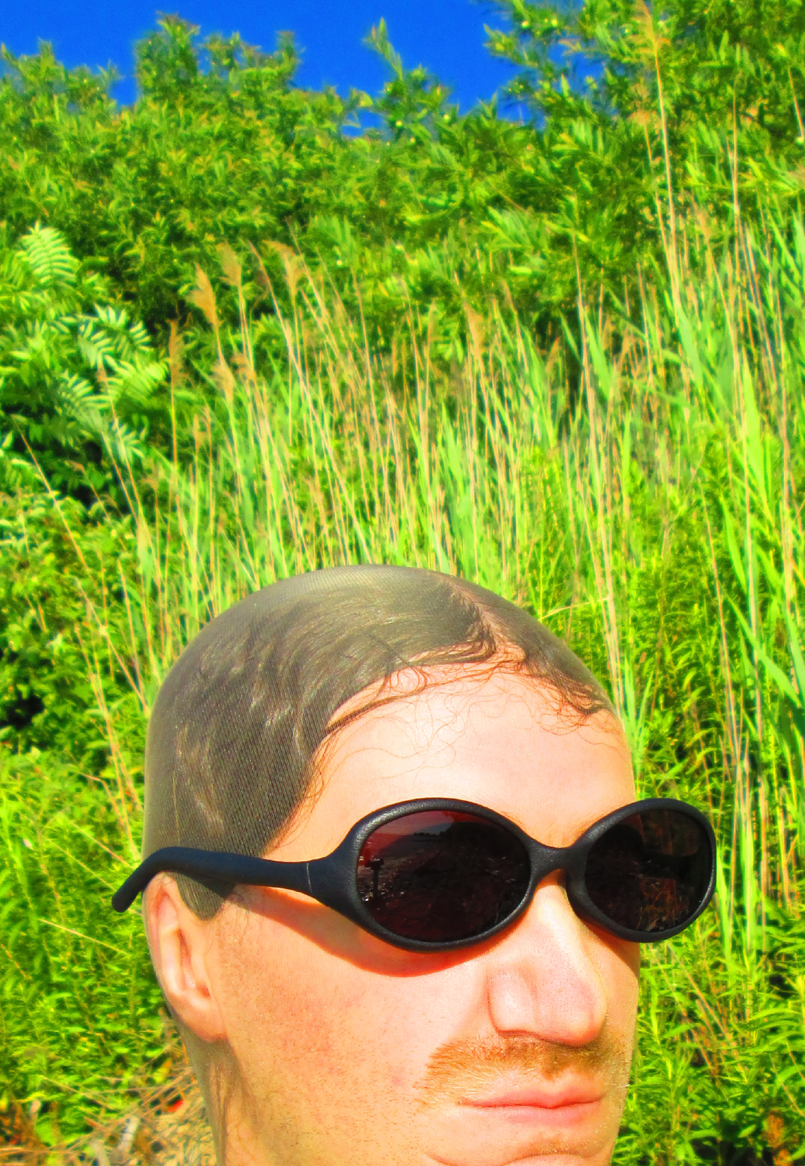 3D render of a bald model wearing black sunglasses with transparent grey lenses